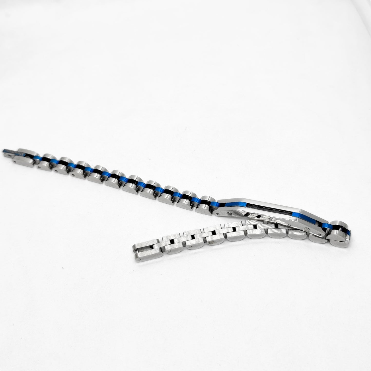 Stainless steel bracelet with blue accents and clasp laid flat on surface