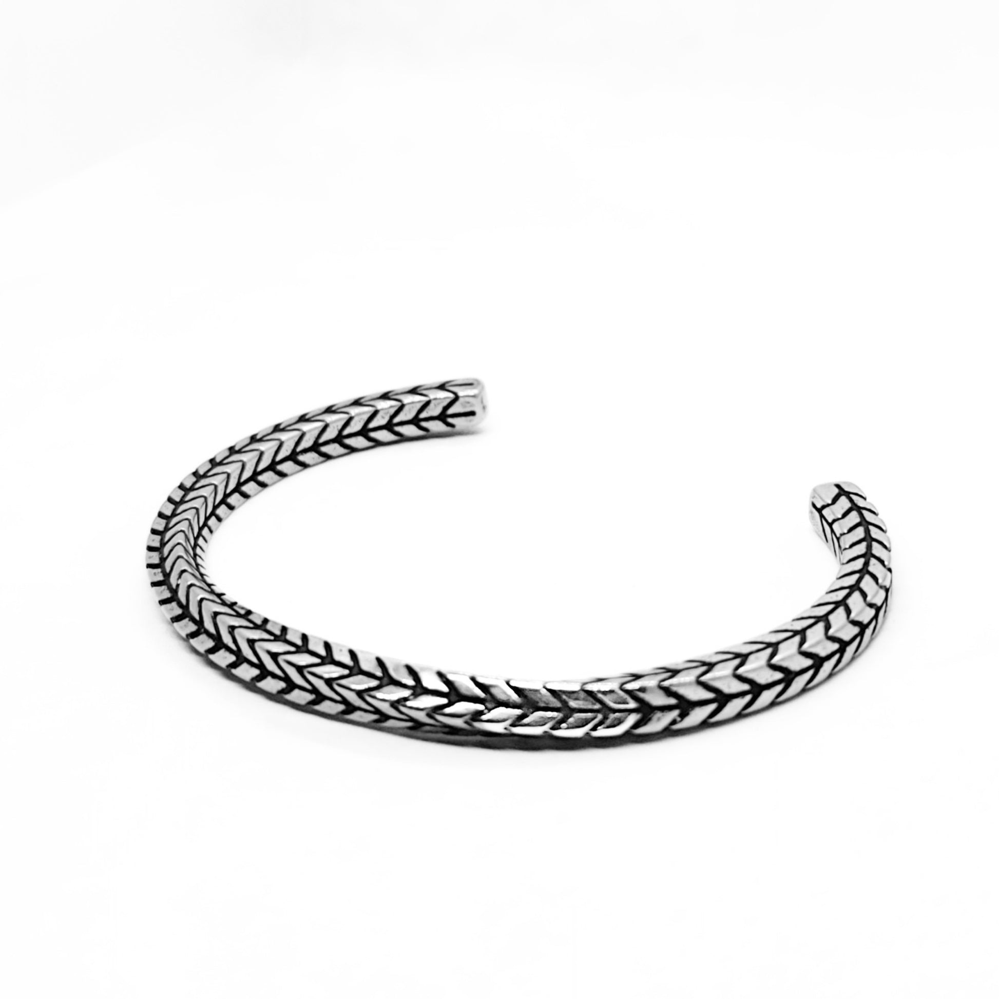 Silver stainless steel braided cuff bracelet, close-up profile, open ends.