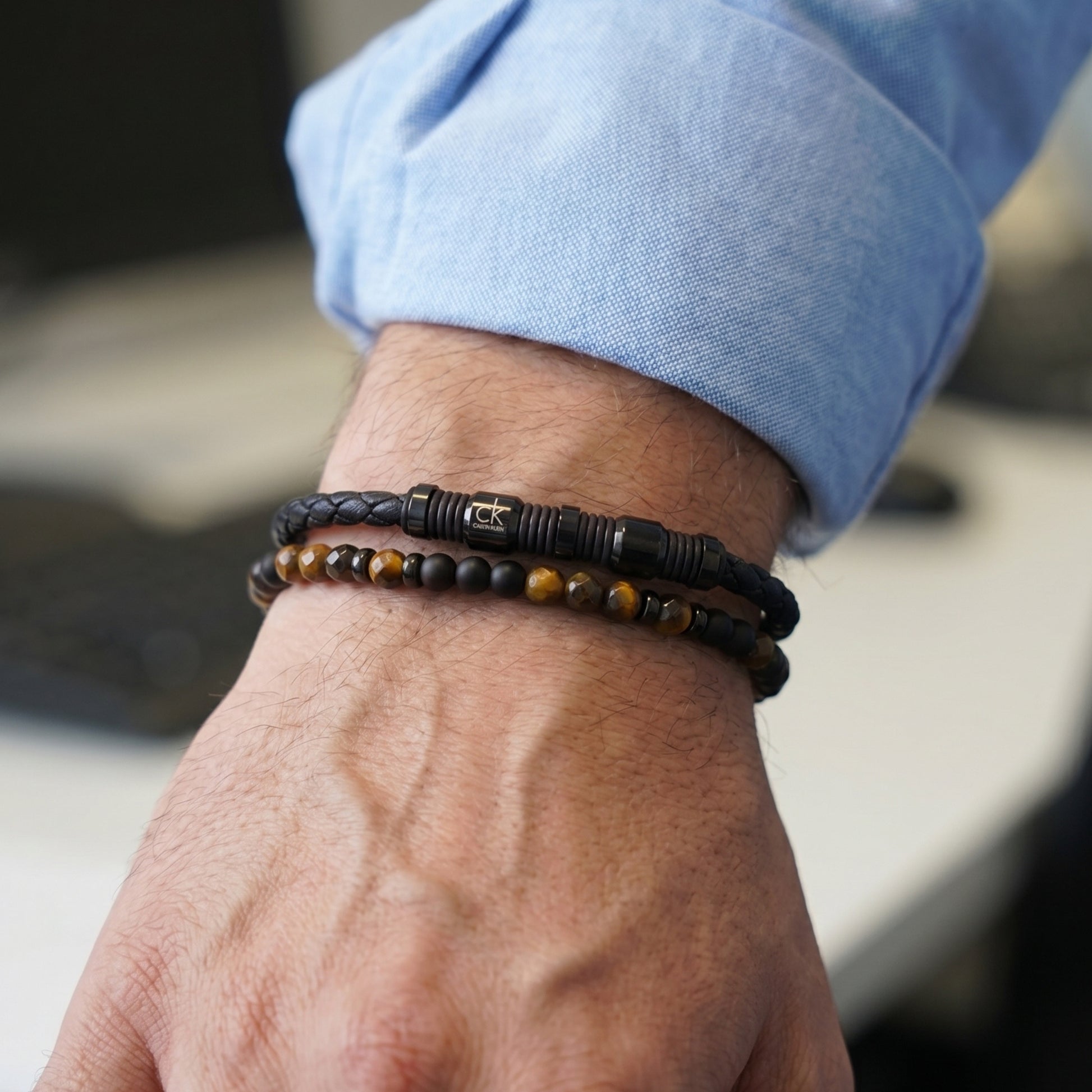 Men's wrist wearing black leather beaded bracelet with tiger eye and onyx beads