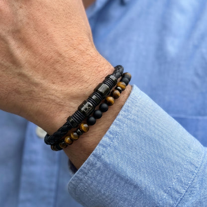 Close-up of men's wrist bracelet: braided black leather with tiger eye and onyx beads