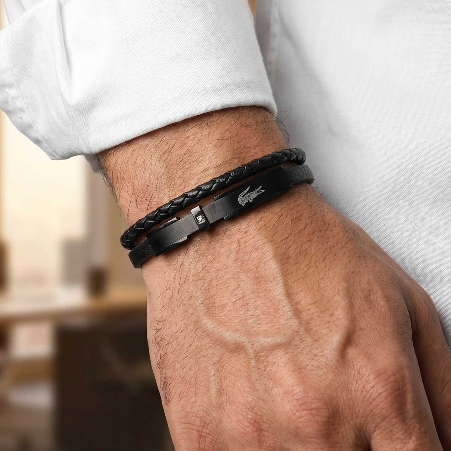 Men's black leather braided bracelet on wrist with rectangular metal clasp