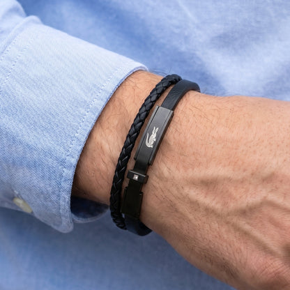Men's black leather braided bracelet on wrist with metal clasp and logo