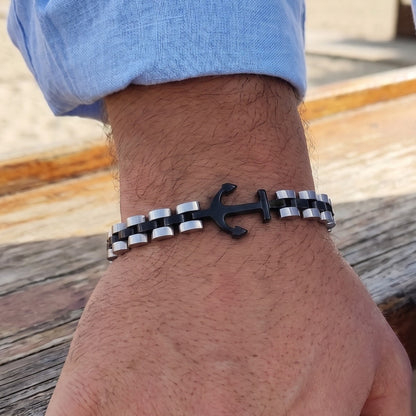 Anchor bracelet with black anchor charm and two-tone silver/dark link chain on wrist.