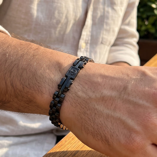 Men's black stainless steel anchor bracelet on wrist with rectangular anchor charm