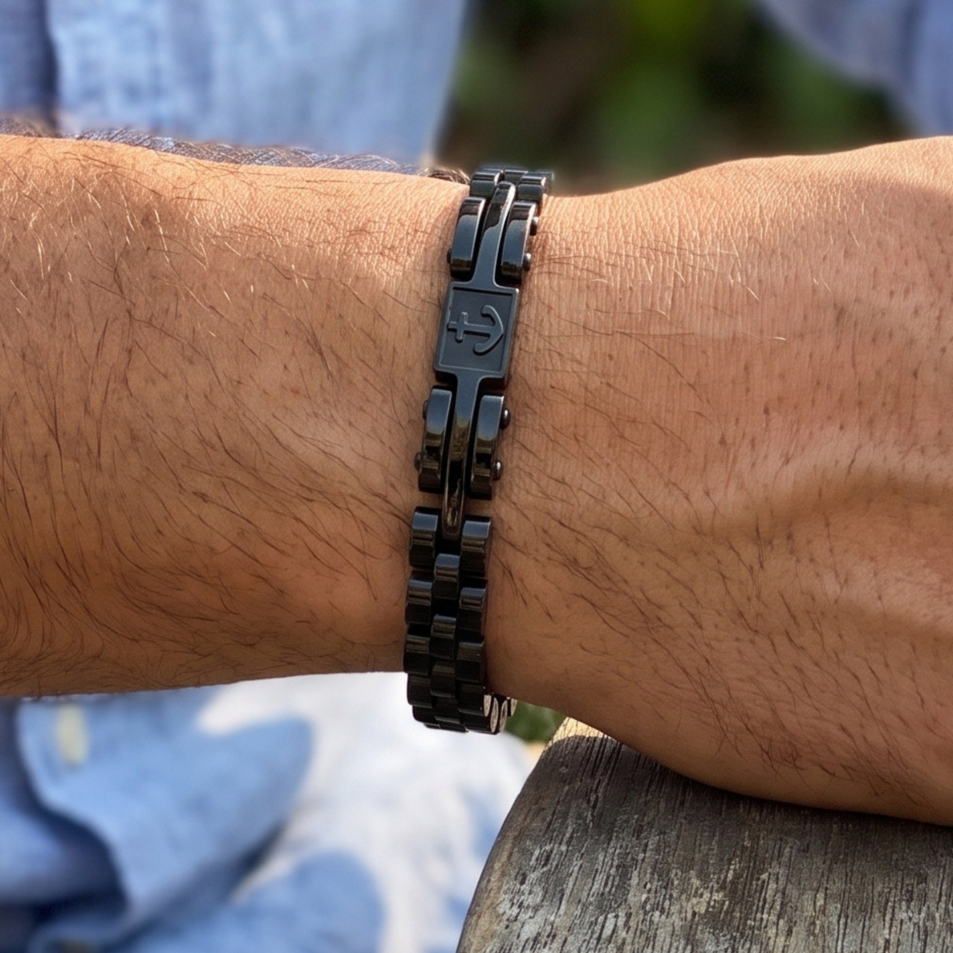 Men's black stainless steel anchor bracelet with segmented link chain on wrist