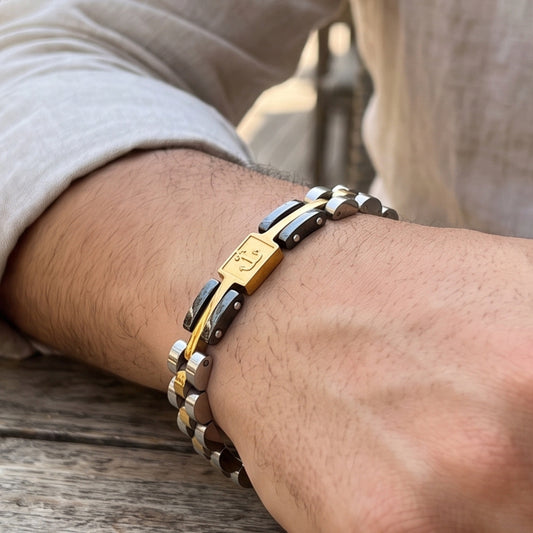 Tri-tone anchor bracelet on wrist, silver links with gold accents and black panels