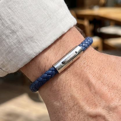 Dark blue braided leather bracelet with silver clasp detail on wrist
