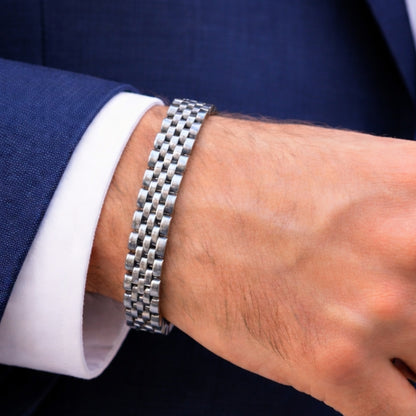 Men's silver stainless steel link bracelet with checker-style pattern on wrist