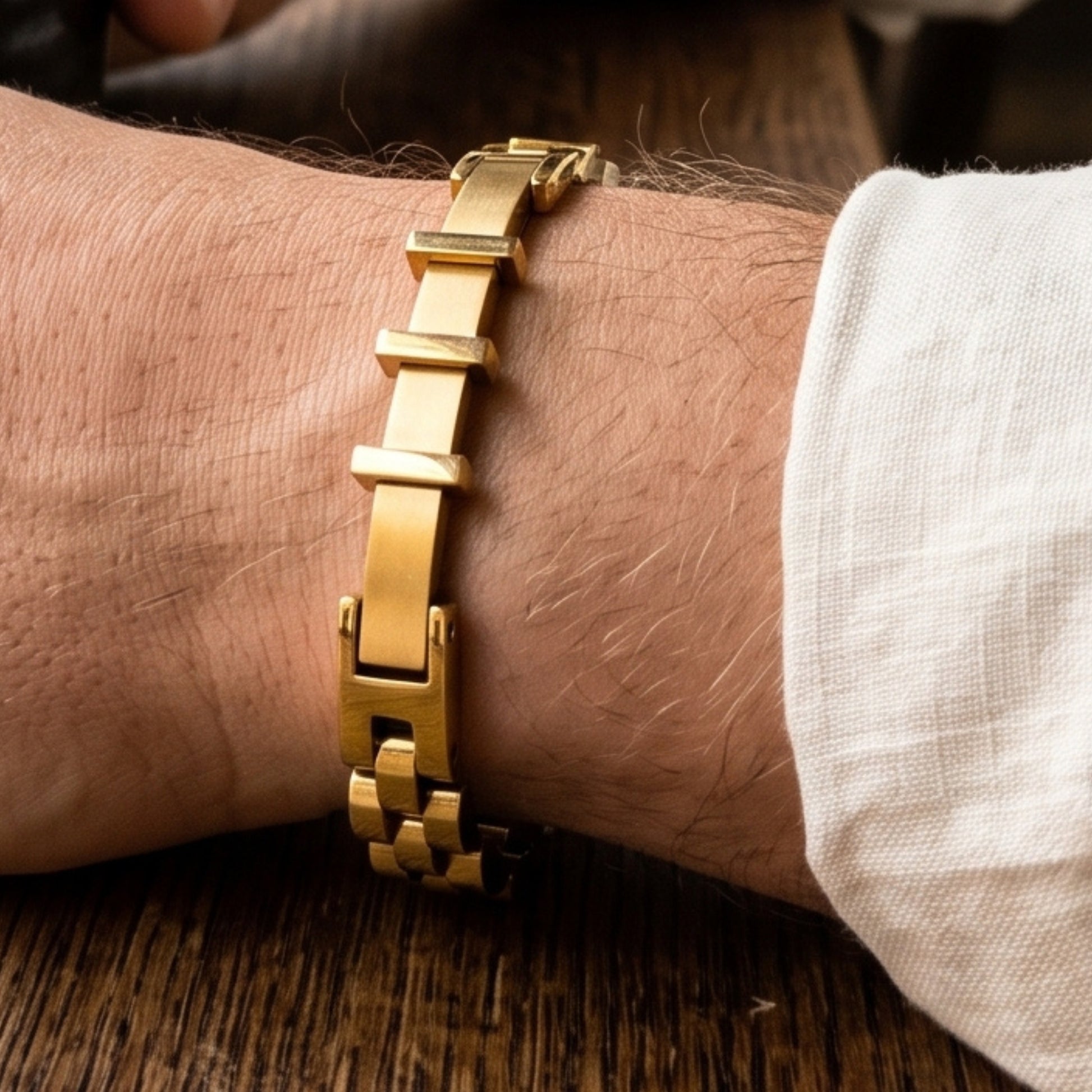 Gold stainless steel bracelet on wrist with rectangular bar links and box clasp closure