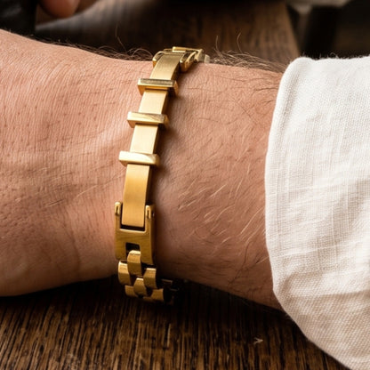 Gold stainless steel bracelet on wrist with rectangular bar links and box clasp closure