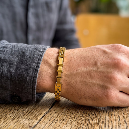 Gold stainless steel bracelet on wrist with slim bar-link design and box clasp