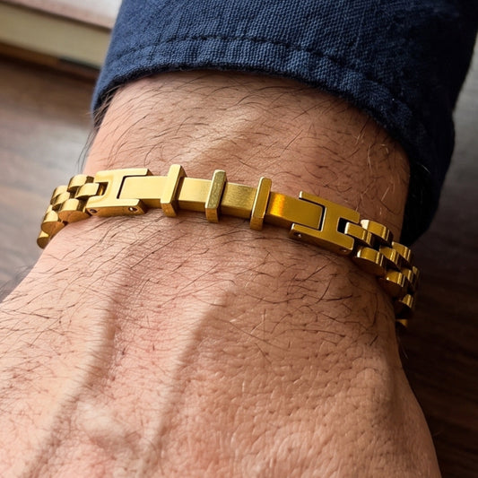 Gold stainless steel bracelet on wrist featuring rectangular plates and chain links