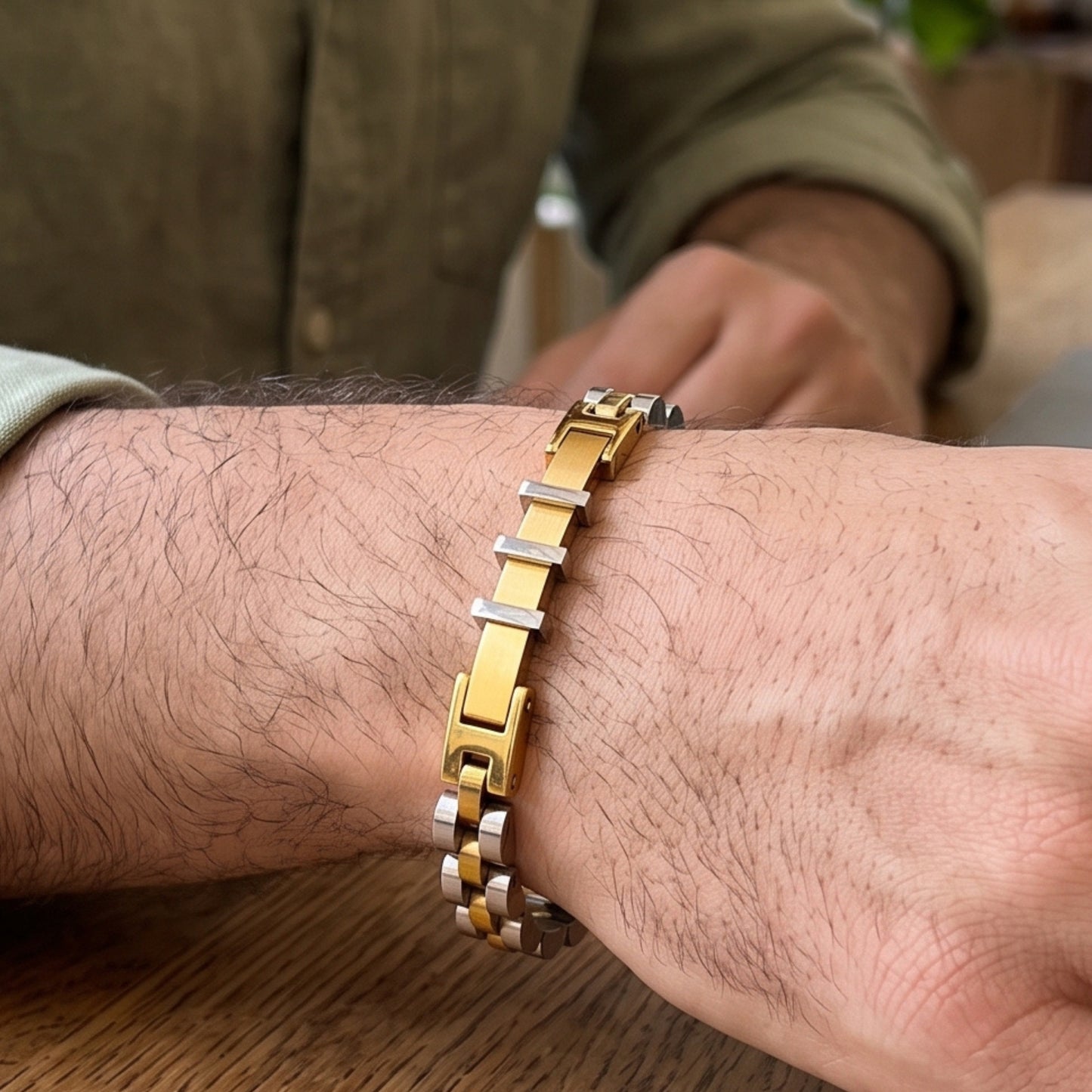 Two-tone stainless steel bracelet on wrist, gold square links and silver bands