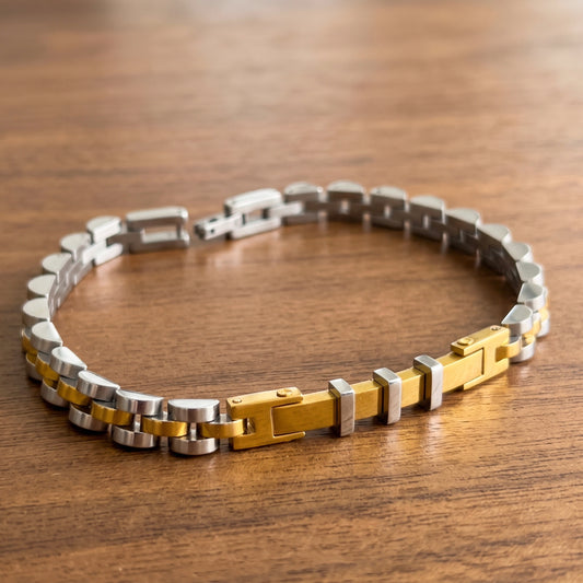 Two-tone stainless steel bracelet laid flat, alternating silver and gold link design