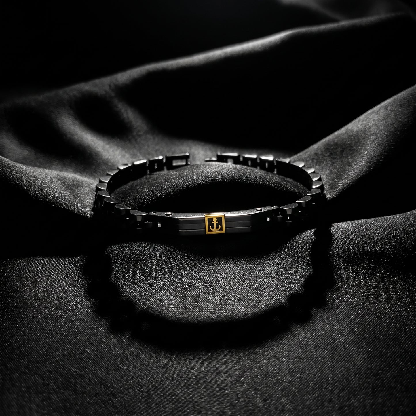 Men's stainless steel bracelet with black links and gold anchor centerpiece