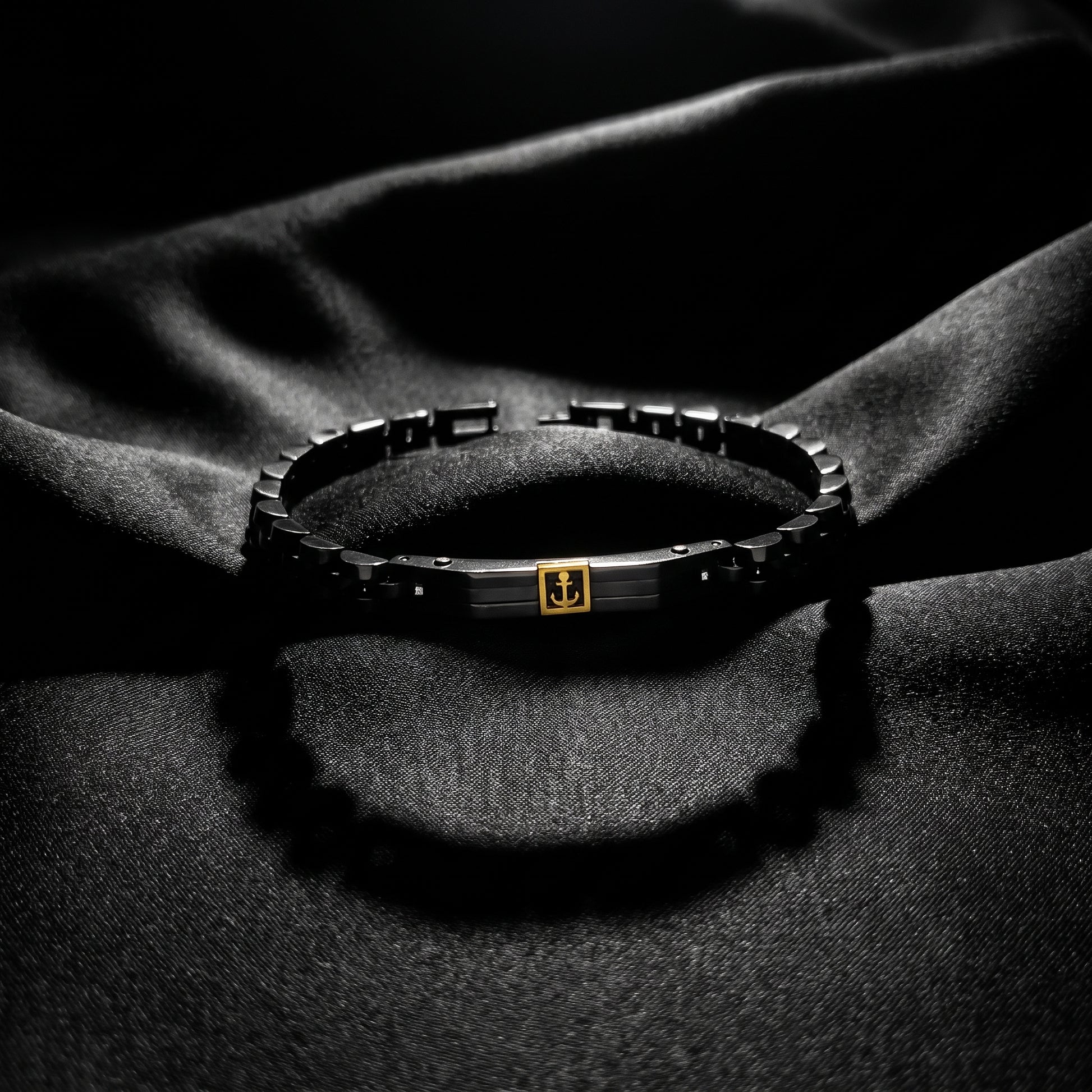 Men's stainless steel bracelet with black links and gold anchor centerpiece