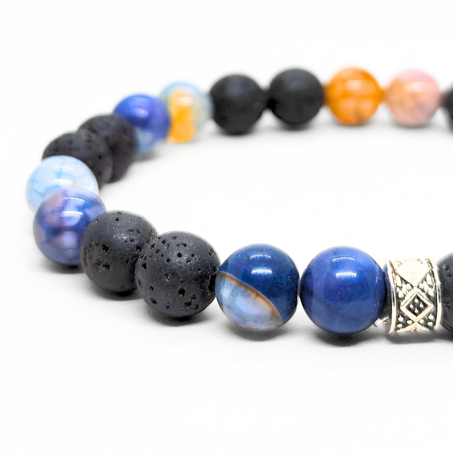 Men's bracelet detail with black lava beads, blue agate beads, and silver geometric charm