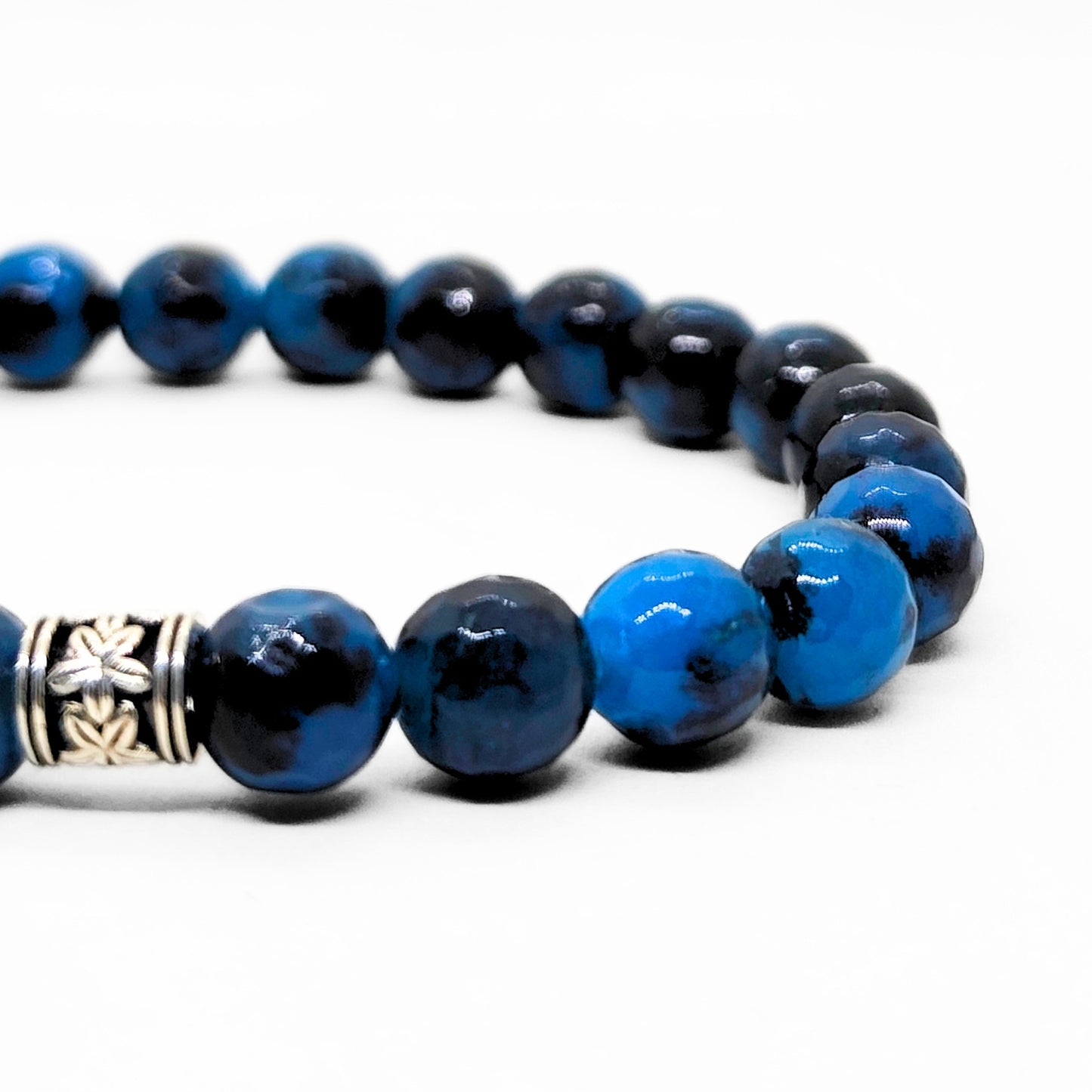 Close-up of blue and black stone beads bracelet with silver carved clasp