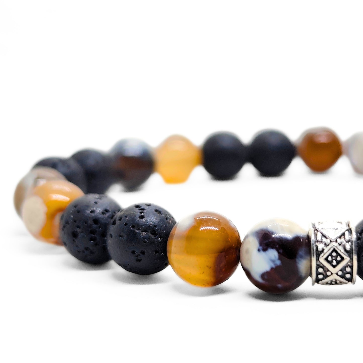 Close-up beaded bracelet with black lava beads, orange center stone, white agate, and silver spacer