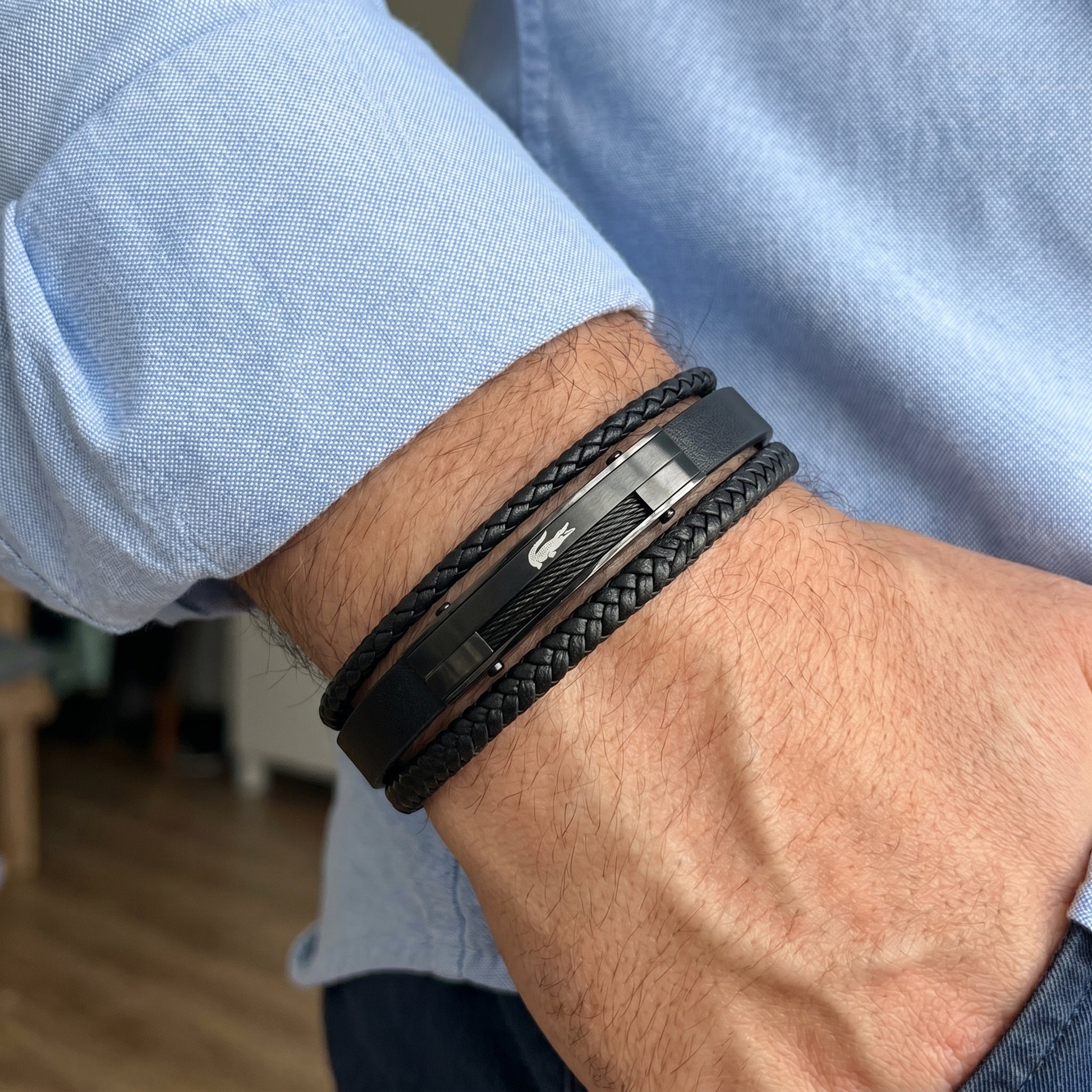 Men's black leather bracelet with braided texture and engraved rectangular metal center