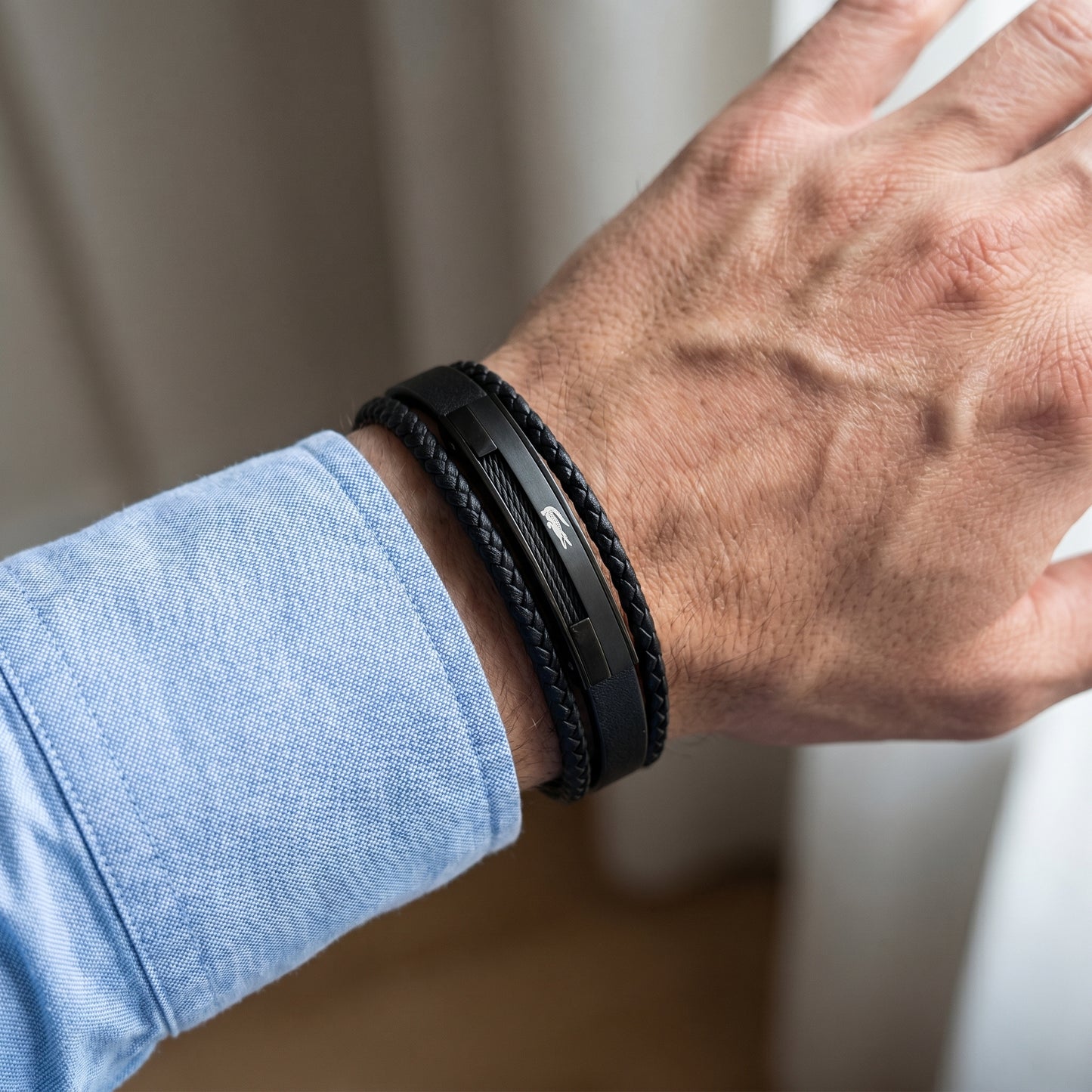 Men's black leather wrap bracelet with braided strands and triple black clasp plates