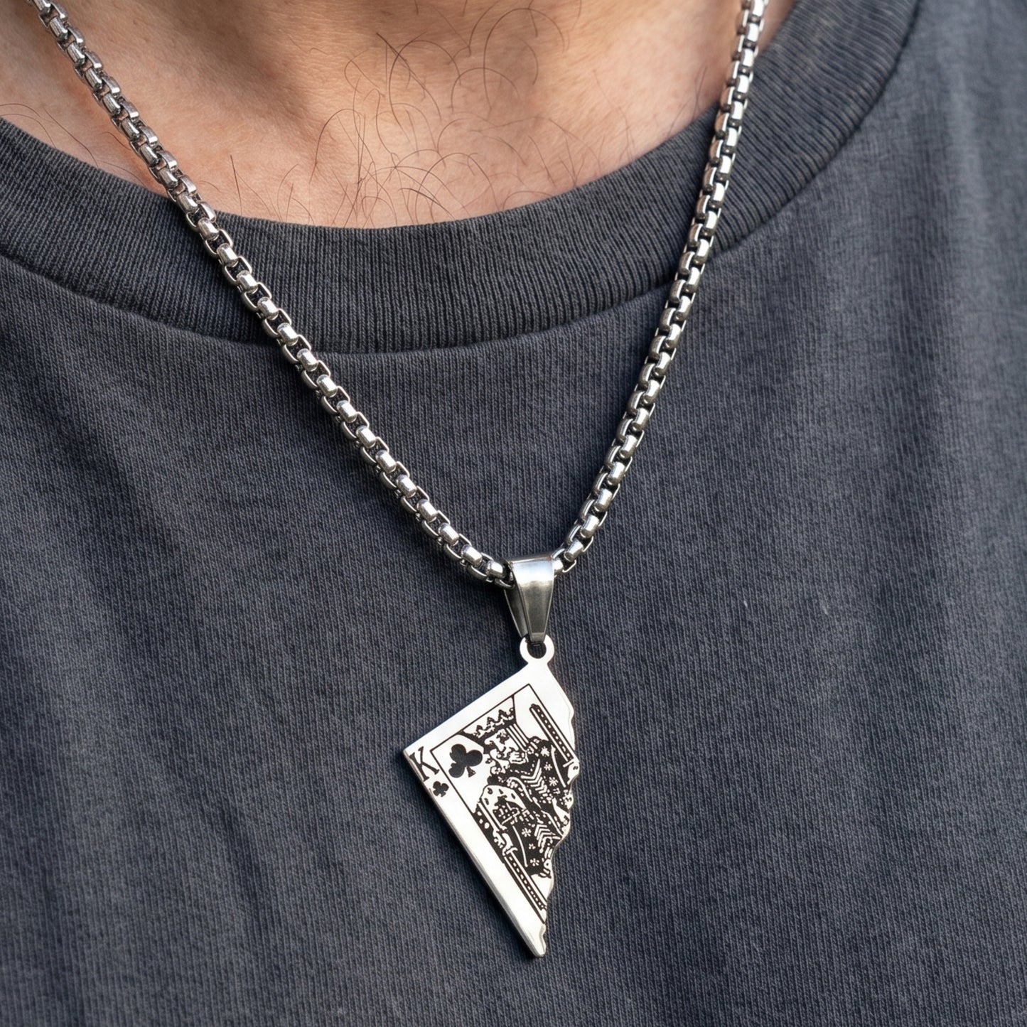 Silver King Card Pendant necklace on a chain, worn on a gray shirt, featuring intricate card design details.