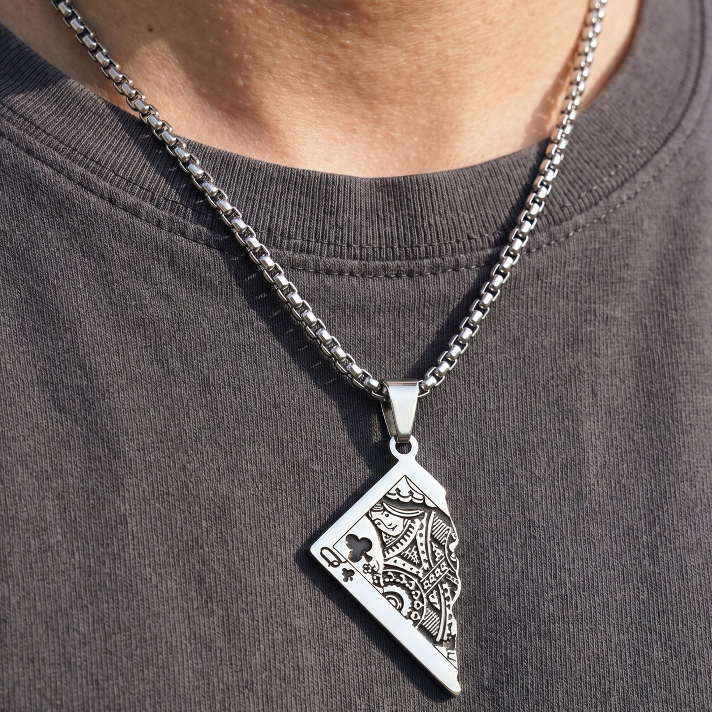 Silver PN-10 Queen Card Pendant necklace on a chain, worn by a person in a dark shirt. Intricate card design visible.