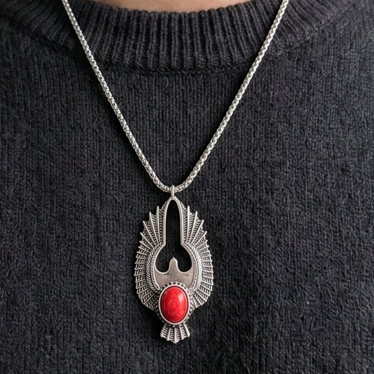 Silver-tone eagle pendant necklace with red oval stone hanging on metal chain