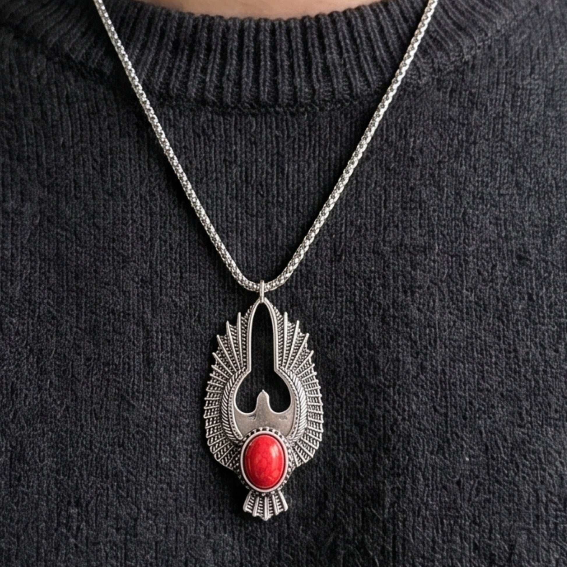Silver-tone eagle pendant necklace with red oval stone hanging on metal chain