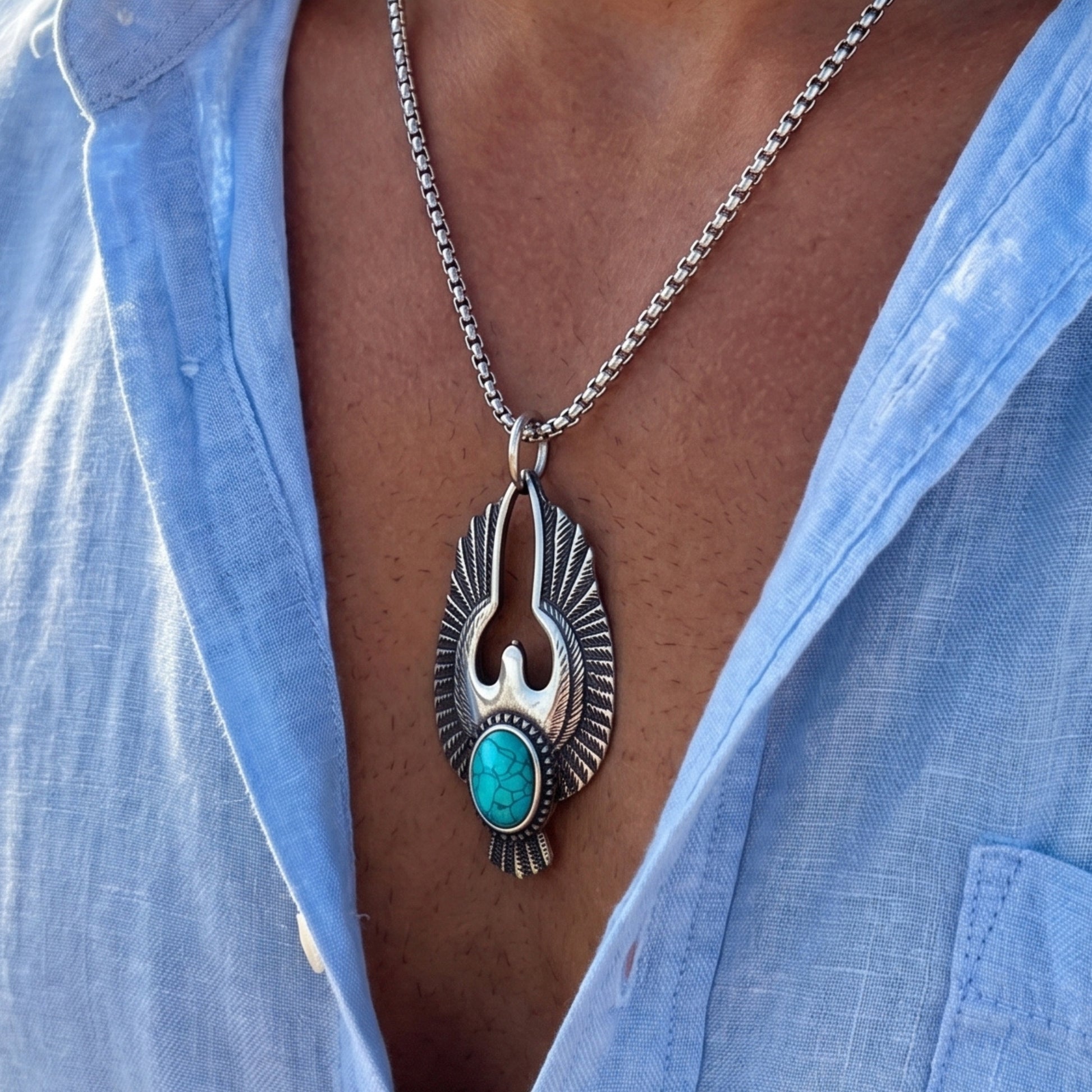 Silver eagle pendant necklace with turquoise stone hanging on a chain