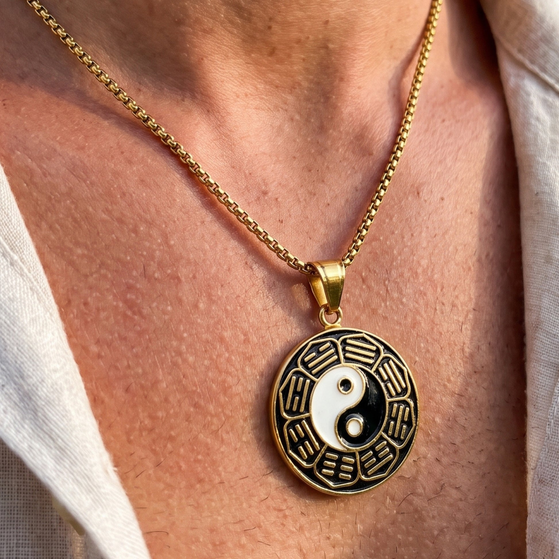 Gold yin-yang pendant necklace with round charm featuring black and white symbols