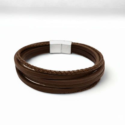 Brown leather wrap bracelet with braided cord and brushed silver metal clasp, laid flat