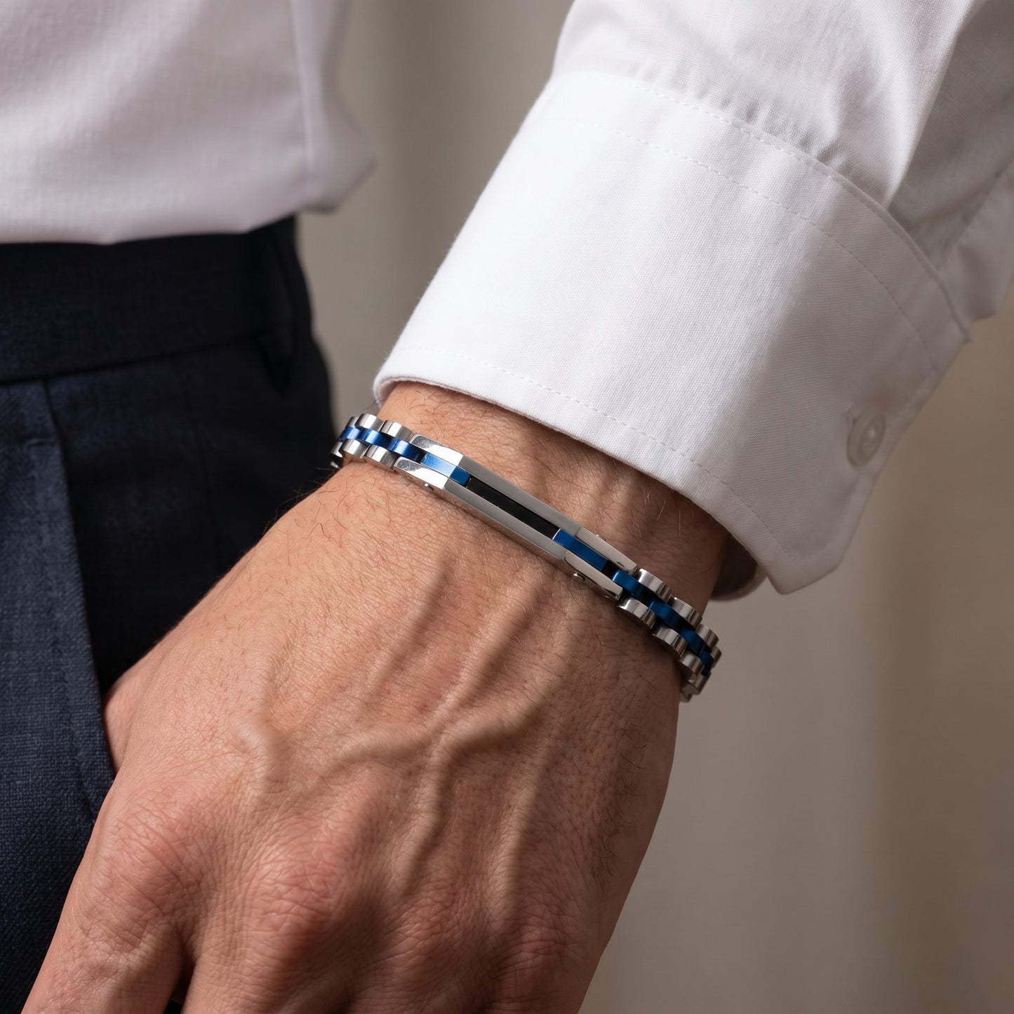 Stainless steel bracelet with blue accents worn on a man's wrist