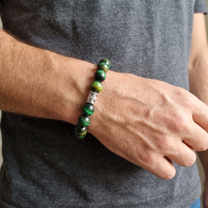 Men's wrist wearing green tiger's eye stone beaded bracelet with silver-toned clasp.