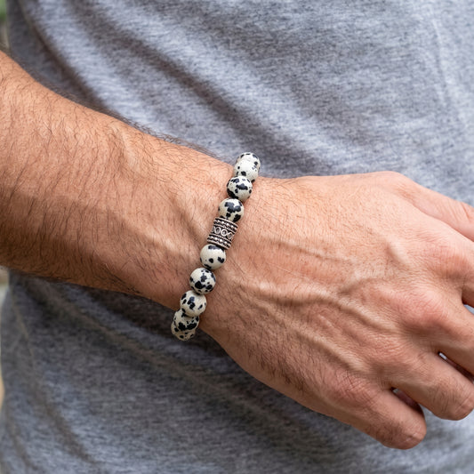 Dalmatian jasper bead bracelet on wrist, round black-and-white beads with silver-tone divider