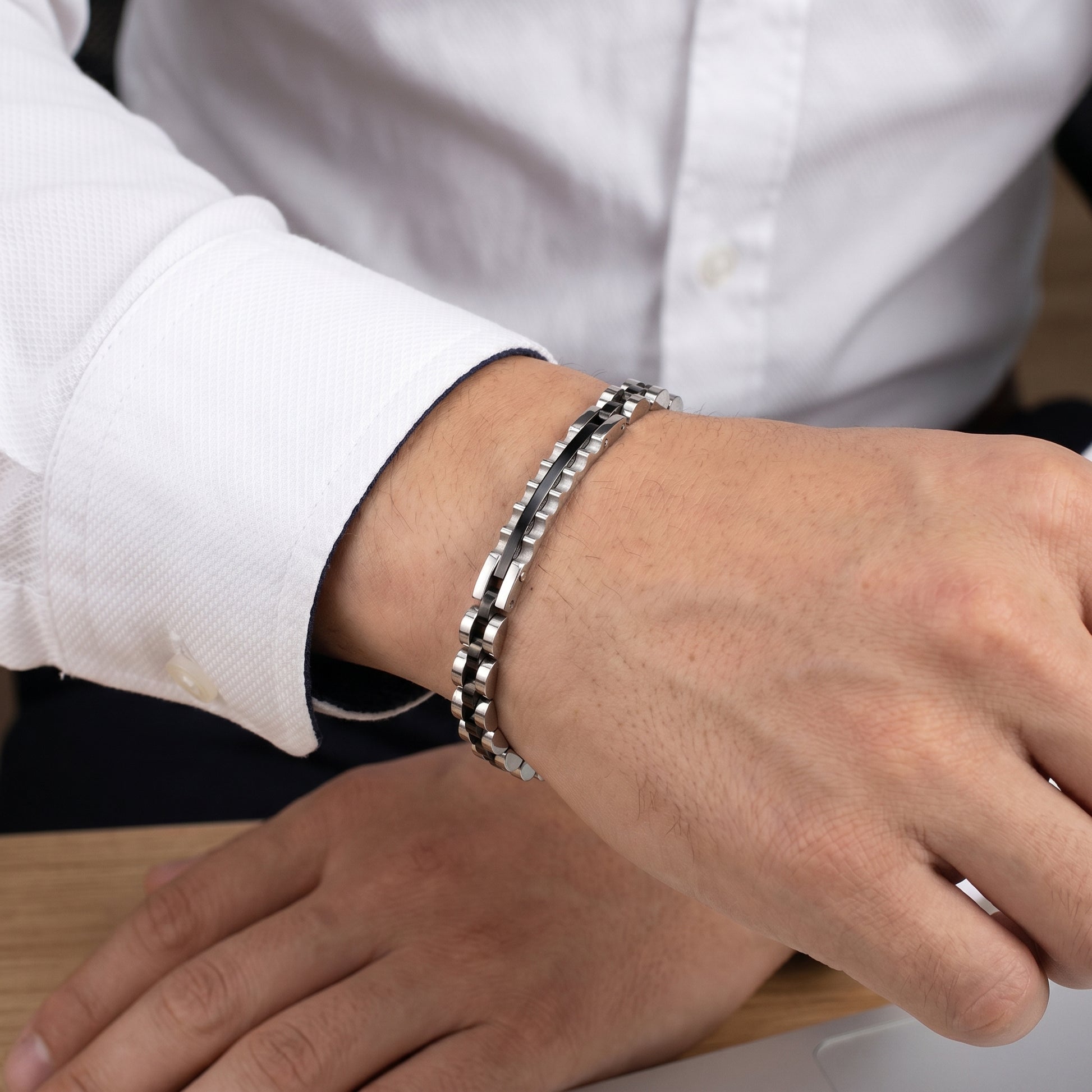 Elegant Silver & Black Stainless Steel B-133 Bracelet worn on a man's wrist, showcasing a stylish design with a polished fini