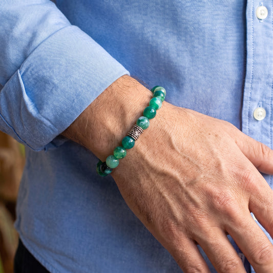 Green agate bead bracelet worn on man’s wrist with silver-tone centerpiece