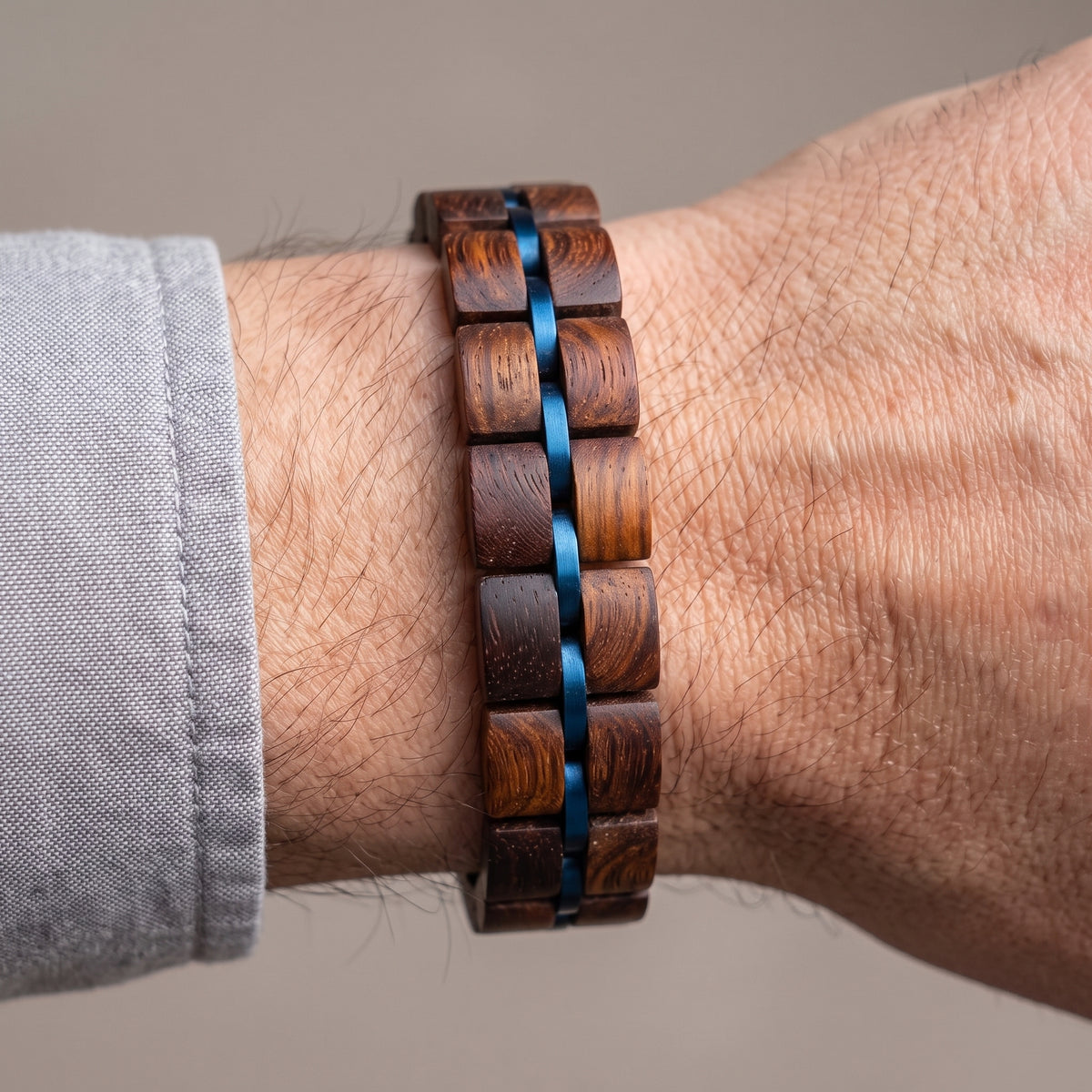 Men's rosewood wood block bracelet with blue ribbon-style inlays, worn on wrist, Overpowered Accessories