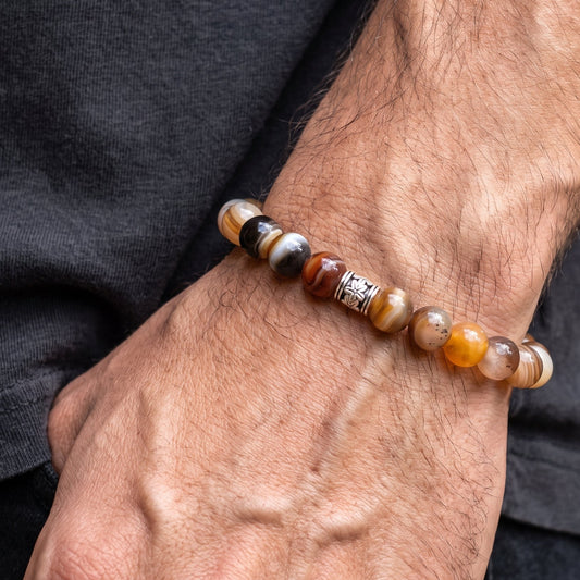 Agate bead bracelet worn on wrist with brown, black, and white round stones