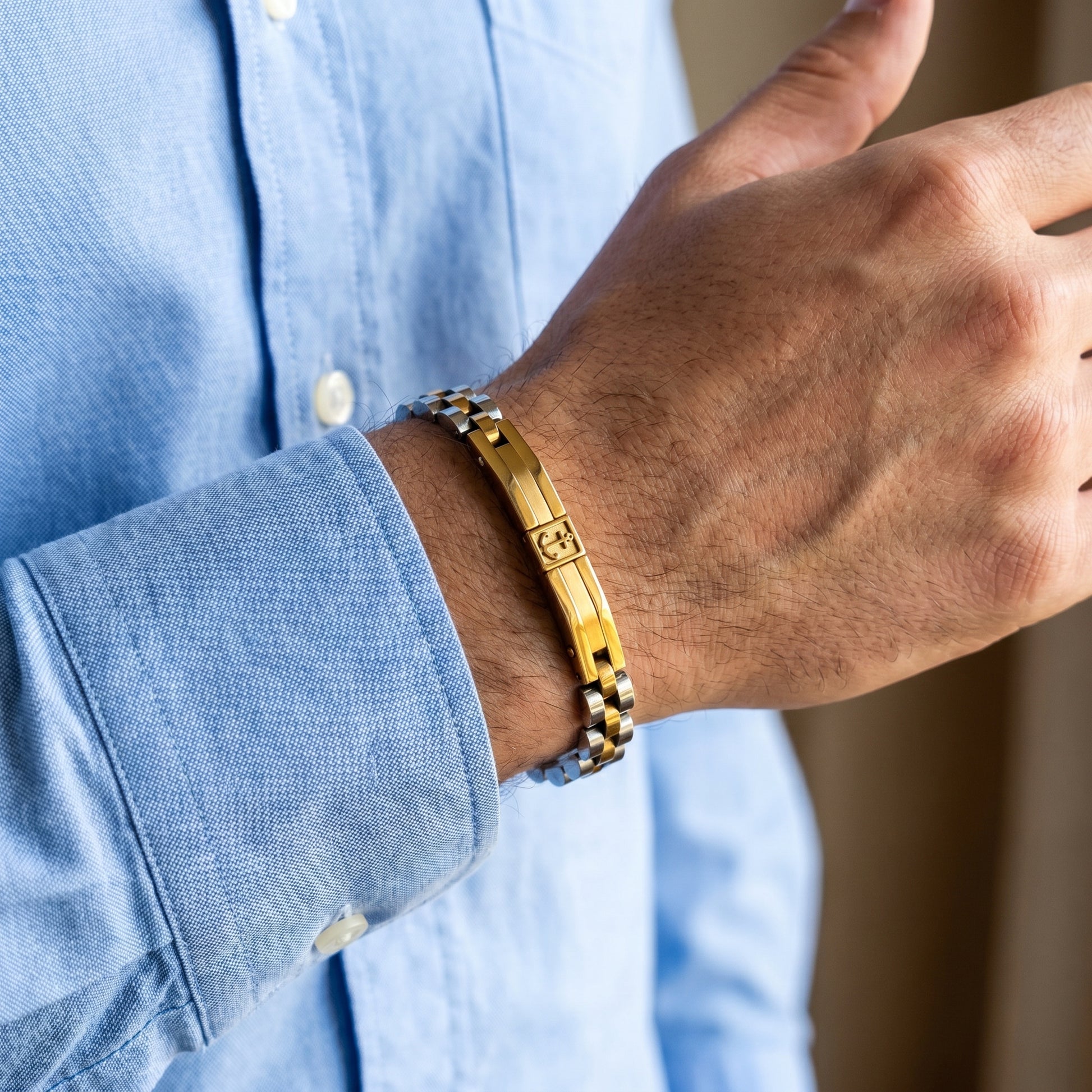 Gold-and-silver anchor bracelet on wrist with gold center bar and silver link chain