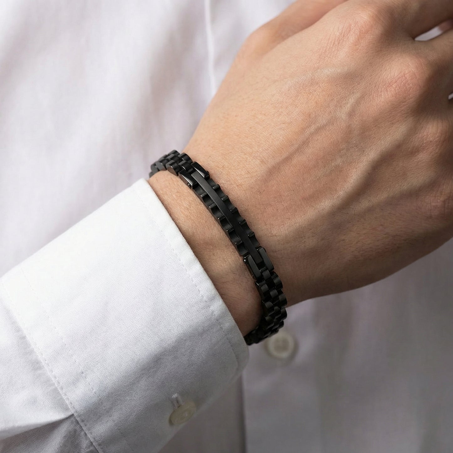 Men's black stainless steel link bracelet close-up on wrist, rectangular segments