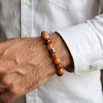 Men's brown stone bead bracelet worn on wrist over a light button-up shirt