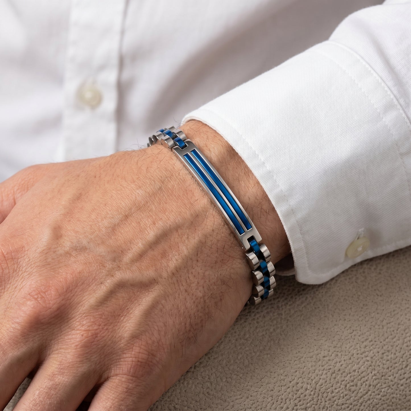 Close-up of stainless steel bracelet with blue inlay stripe on man's wrist