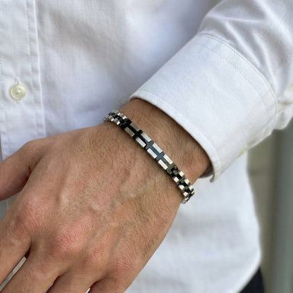 Stainless steel bracelet with black and silver cross-style link pattern, on wrist