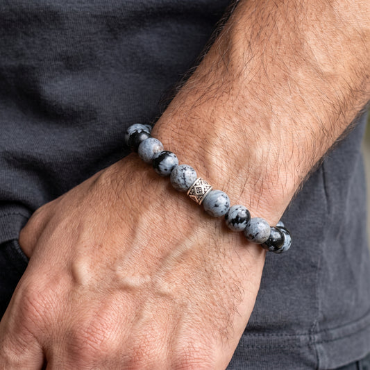 Obsidian bead bracelet on a man’s wrist; round gray-and-black stones with silver centerpiece