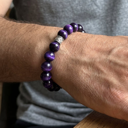 Purple and black bead bracelet on wrist with patterned silver-tone spacer beads