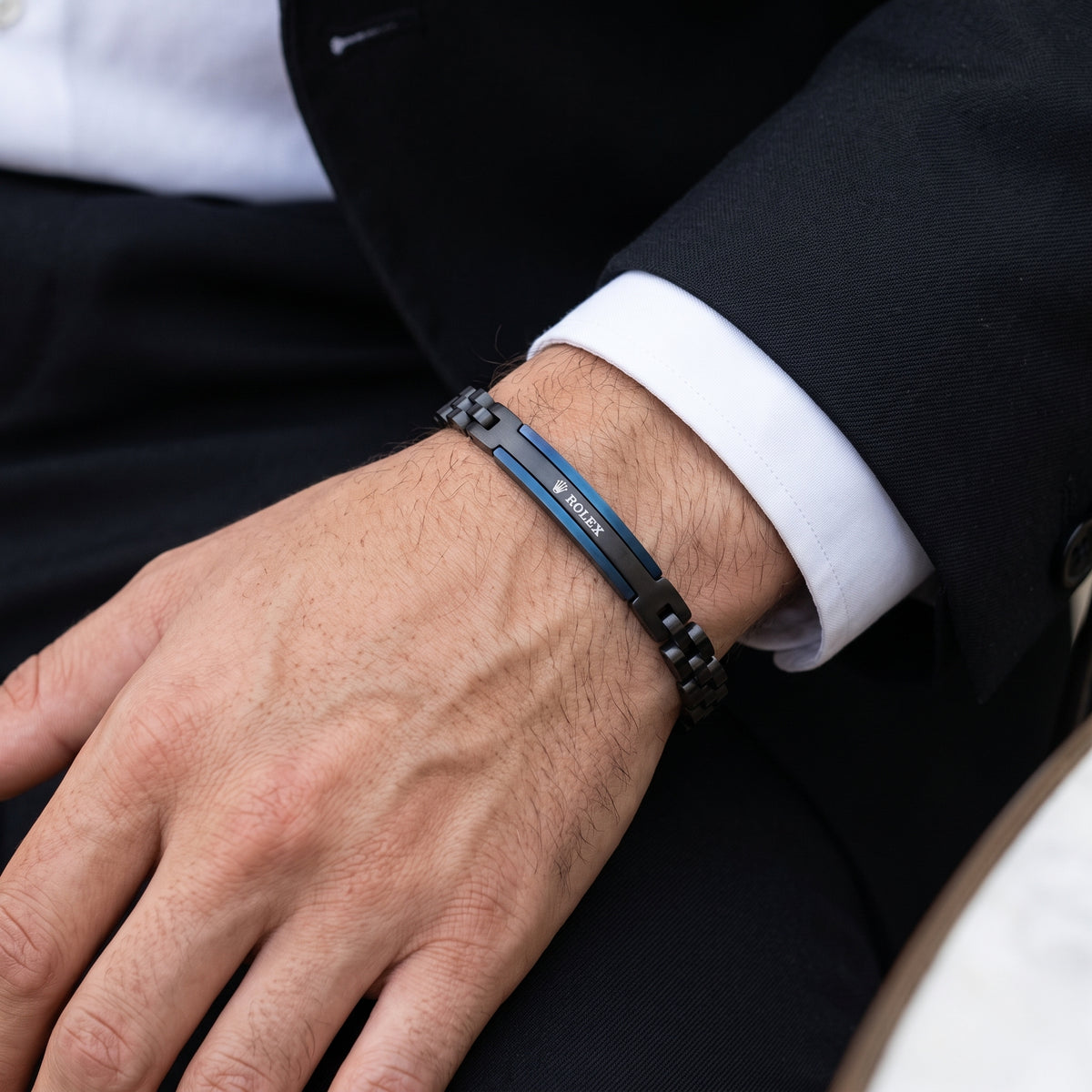 Men's adjustable black and blue ID link bracelet with steel clasp on wrist