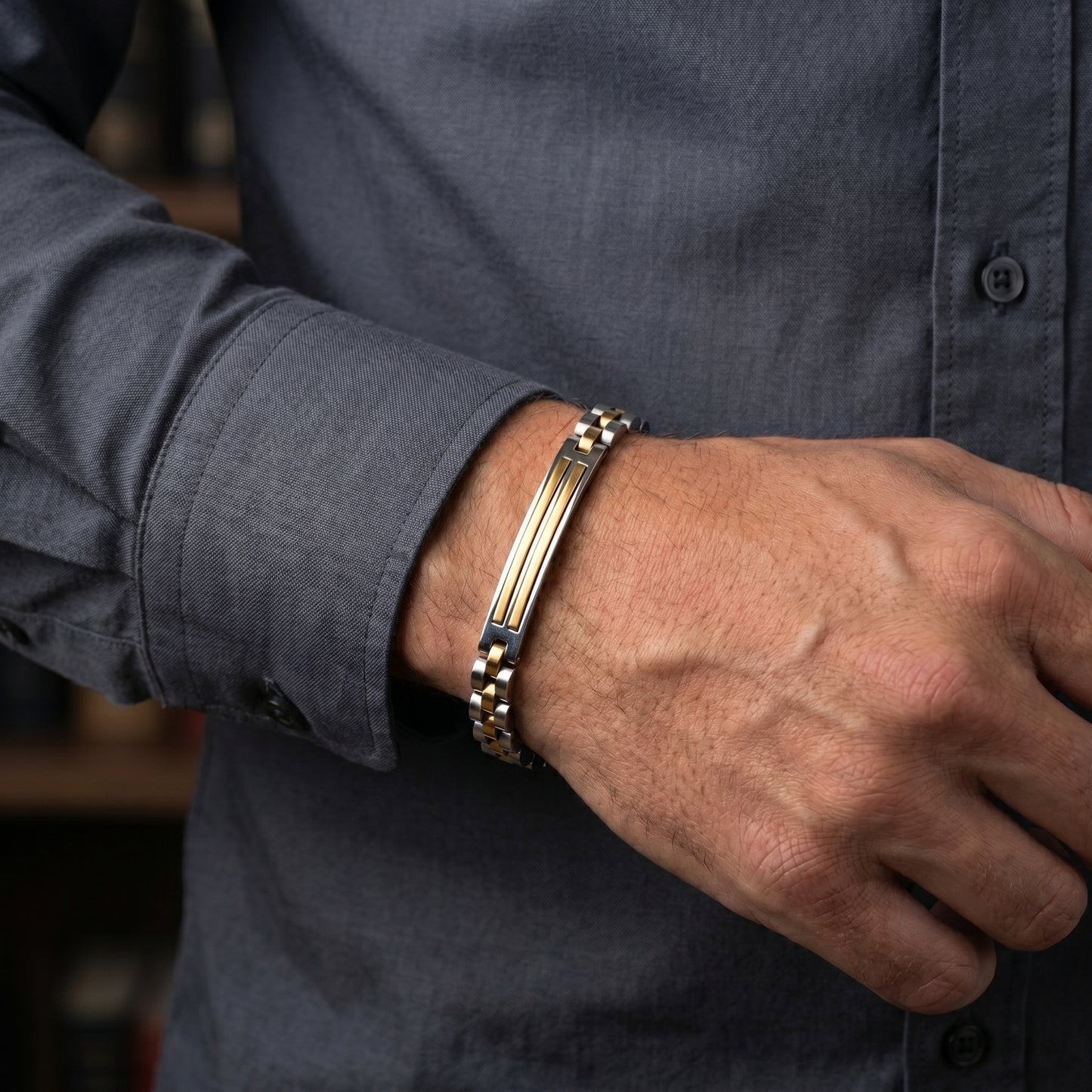 Bracelet on man's wrist: silver curb links with gold bars and amber center stripe