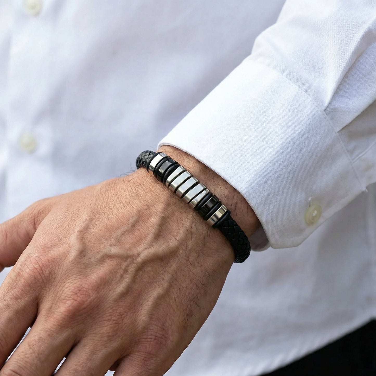 Men's Cobalt Nexus Bundle B-124 B-87 bracelets featuring a black braided band and metallic accents, worn on a wrist.