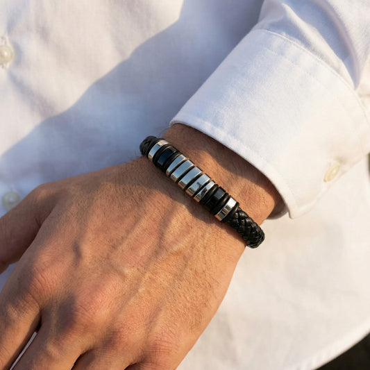 Men's black leather bracelet with silver barrel accents on wrist